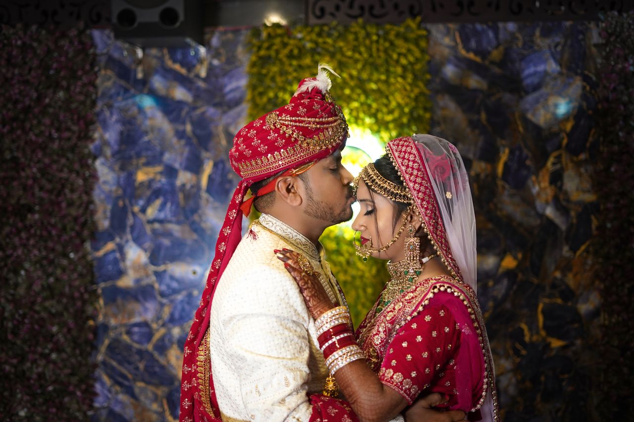 gallery-4 Elegant Indian wedding couple sharing an intimate embrace in traditional attire.