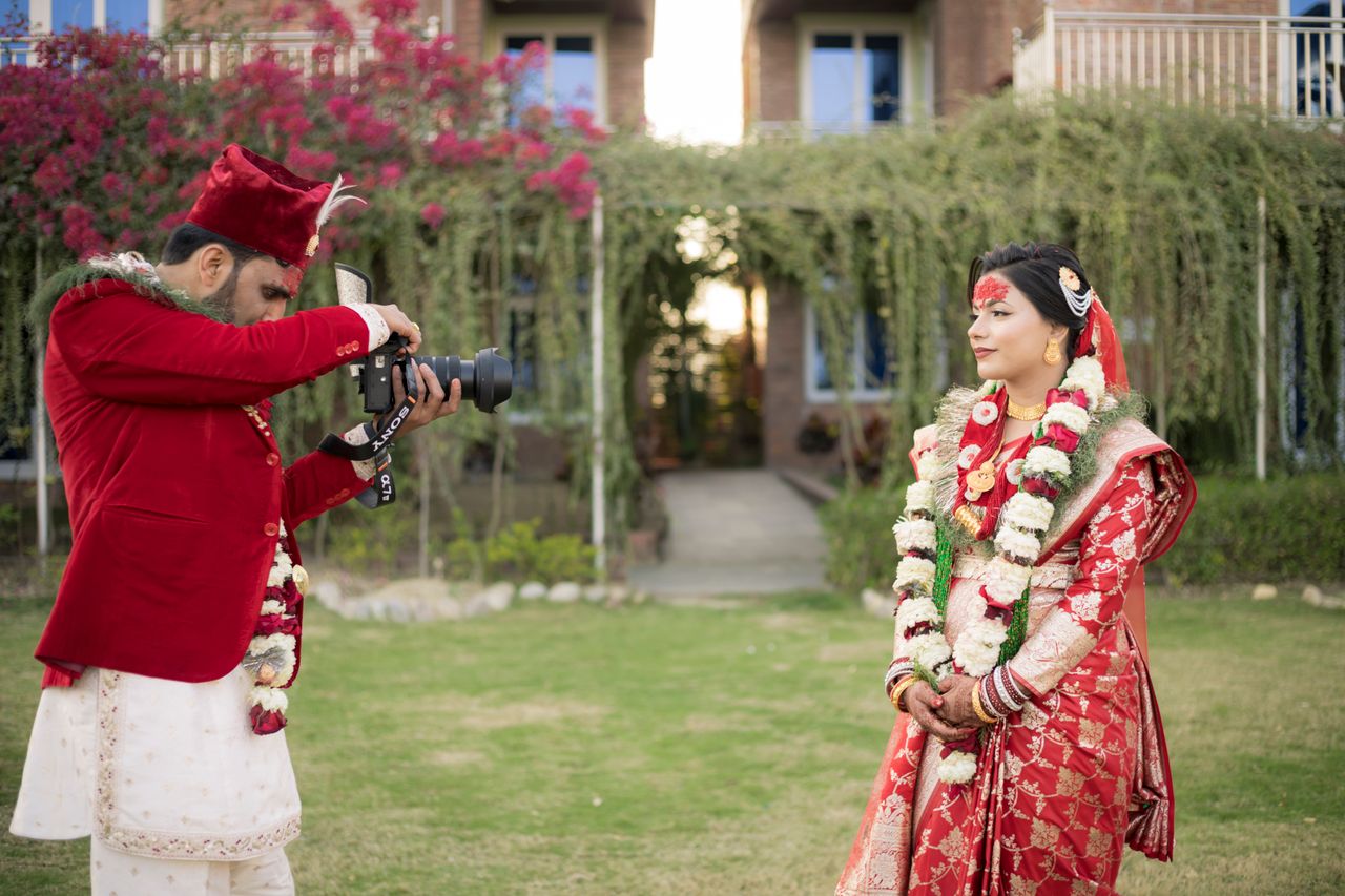 about-img A vibrant Nepali bride poses during an outdoor wedding photoshoot, capturing cultural traditions.